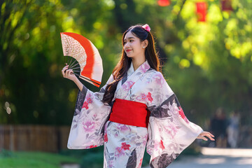 Young women wearing traditional Japanese kimono or yukata is happy and cheerful in the park.