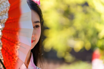 Young women wearing traditional Japanese kimono or yukata is happy and cheerful in the park.