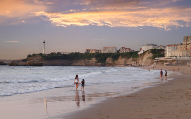 Biarritz, France. People walking along the beach and enjoying sunset.