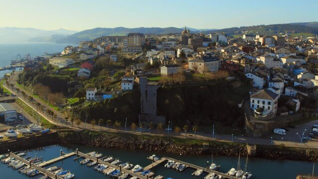 Aerial shot, drone point of view, panorama Ribadeo city and harbor with moored nautical vessels during sunny winter day. Province of Lugo in Galicia. Europe, Northern Spain. Travel and tourism concept