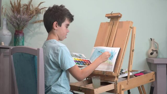 boy in art studio draws, child, art, painting, easel, paints, brush, paper, jug, bouquet, green background