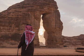 Man in desert looking at Al Ula most attractive place known as Elephant Rock which is situated in...