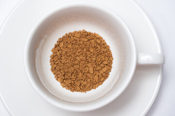 Freeze-dried instant granulated coffee in a cup on a white background close-up