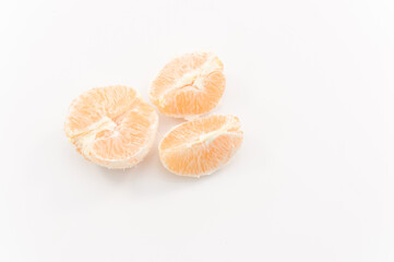 primo piano con spicchi di frutto di arancia sbucciata su superficie bianca, vista dall'alto...
