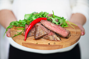 Sliced medium rare grilled Beef steak Ribeye in hands of a woman