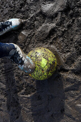 soccer ball stationary on a muddy soccer field