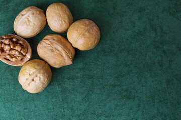 six walnuts in shell and one without shell on a green background..Bertholletia healthy eating concept. Super food.