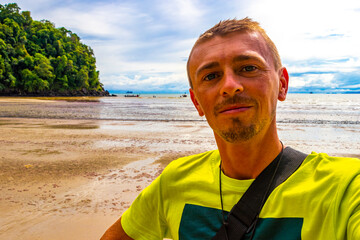 Man takes selfie photo tropical paradise beach Ao Nang Krabi Thailand.