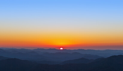 A view of the sun setting over the mountains. sunset