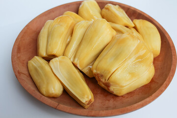 Yellow Jackfruit flesh from Artocarpus heterophyllus, on wooden plate, isolated on white background