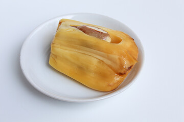 Yellow Jackfruit flesh and its seed from Artocarpus heterophyllus, on small white plate, isolated on white background