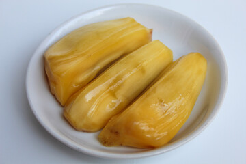 Yellow Jackfruit flesh from Artocarpus heterophyllus, on small white plate, isolated on white background