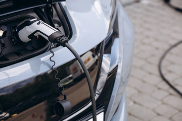 Close up photo of charging electric car with socket