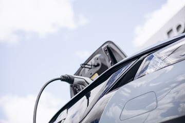 Electric car charging with a blue sky on background