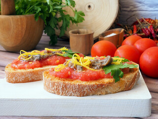 Toast with fresh garlic and ripe tomato, drizzled with olive oil and added anchovies.