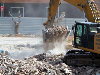 Close-up of an excavator bucket removing debris from a construction site