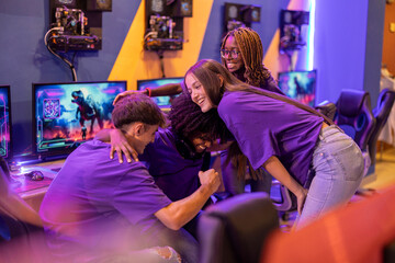 multiracial gamers celebrating victory effort in arena with group hug © Aida