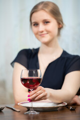 A smiling girl dressed festively sits at a table.