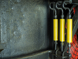 Closeup undercar space of train's equipment system. Red air conditioner fan, yellow condenser pipes