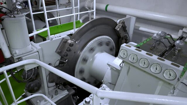Main shaft rotates in motor room of vessel. Shaft disc brake close-up. Shaft from diesel engine to propeller
