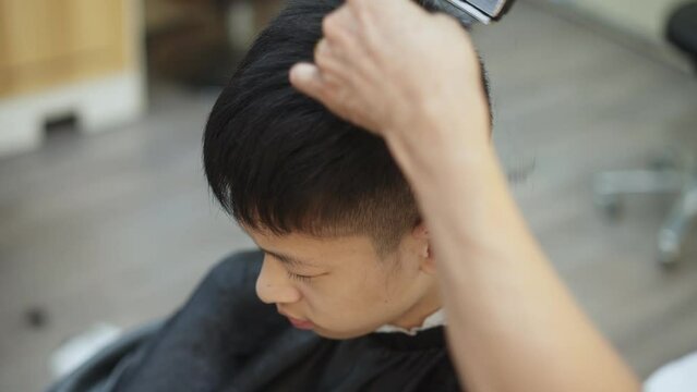boy haircutting in barber shop