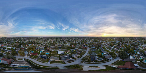 A 360 degree aerial view of the sun rising over a residential area of St Petersburg, Florida, USA