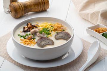 Rice porridge ,Congee with preserved eggs, minced pork, mushroom and ginger in white bowl