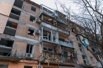 Fototapeta na wymiar Damaged houses after the missile arrived. Broken windows, balconies. Consequences after a strong explosion. War in Ukraine and Russia. Destroyed buildings on the streets of Dnipro