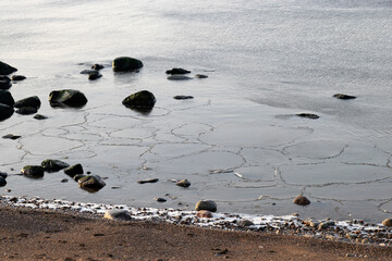 the seashore, rocky seashore, bare ice, sand and ice formations