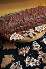 Gingerbread next to a chocolate roll on a dark background