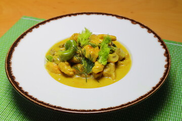 Delicious chicken with curry sauce in bowl, closeup