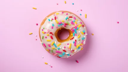 Foto op Plexiglas  a donut with white frosting and sprinkles on a pink background with colored sprinkles. © Anna