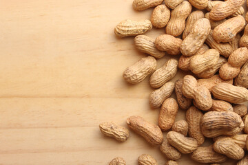 Fresh roasted peanuts on wooden table.