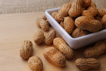 Fresh roasted peanuts on wooden table.