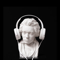 A bust of Beethoven listening music by headphone on black background. music lover concept - 703379732