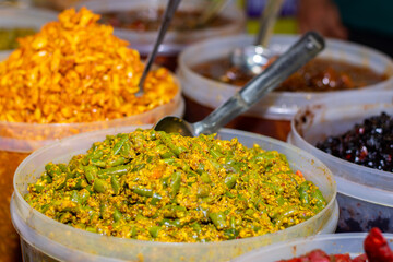 A seller selling delicious Indian Aachar or pickles items at Industrial trade fair in Kolkata, West Bengal, India.