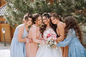 Group portrait of the bride and bridesmaids. A bride in a wedding dress and bridesmaids in...