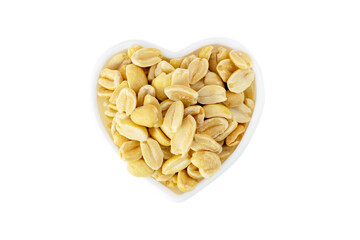 Close-up of dried roasted peeled peanuts in a heart shaped bowl, delicious peanut isolated on white background. Nuts top view. Healthy natural snack.