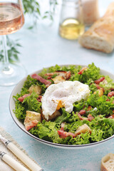 A bowl with salad lyonnaise served for lunch