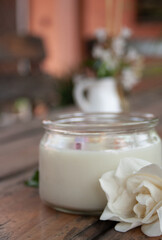 Spa scented candle and white flowers in summer colours background