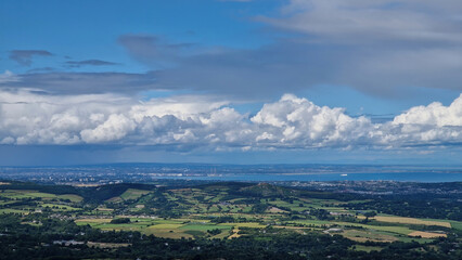 From the heights of the Great Sugar Loaf Mountain, a sweeping aerial perspective reveals the bustling heart of Dublin city juxtaposed with the serene Irish countryside.