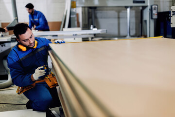 Carpenter working on woodworking machines in carpentry shop. Carpenter working to making wood furniture in wood workshop
