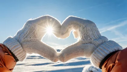 Fotobehang Female hands in winter gloves shaped Heart symbol. Blue sky in the background   © adobedesigner