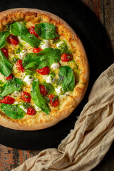 Buffalo Mozzarella Pizza. Neapolitan pizza made with tomato sauce, mozzarella cheese, pesto sauce, arugula and cherry tomatoes