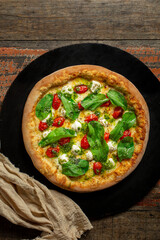 Buffalo Mozzarella Pizza. Neapolitan pizza made with tomato sauce, mozzarella cheese, pesto sauce, arugula and cherry tomatoes