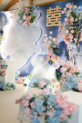 Modern chinese decoration for wedding ceremony or enggament. Blue pink rose. Indoors. Stage. Held on restaurant or ballroom. Chinesse caligraphic double happiness. Celebration. Private party. Dinner.