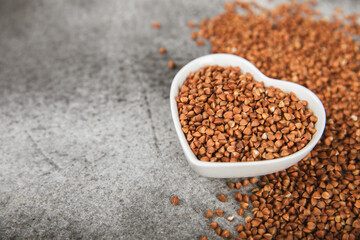 Buckwheat porridge in a bowl on a dark texture background. Healthy food. Diet. Organic cereal.
 Raw buckwheat. gluten free ancient grain for healthy diet. Place for text. Copy space.