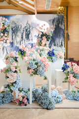 Modern chinese decoration for wedding ceremony or enggament. Blue pink rose. Indoors. Stage. Held on restaurant or ballroom. Chinesse caligraphic double happiness. Celebration. Private party. Dinner.
