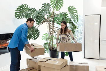 Happy couple with cardboard boxes in new home. Woman holding keys.