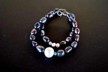 Bracelets with black freshwater pearls isolated on a black surface